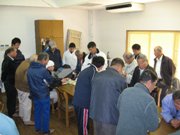 成分分析の状況を見つめる会員